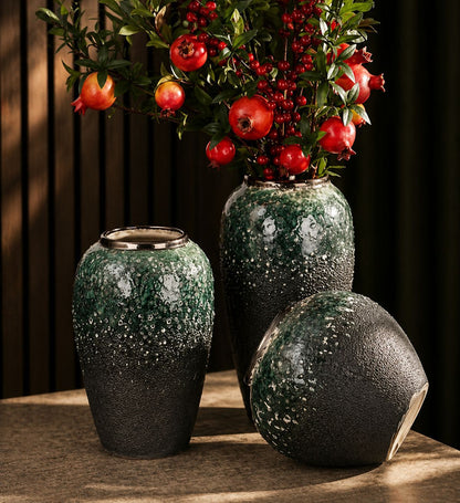 Three dark green decorative vases with elegant gold accents in varying sizes.