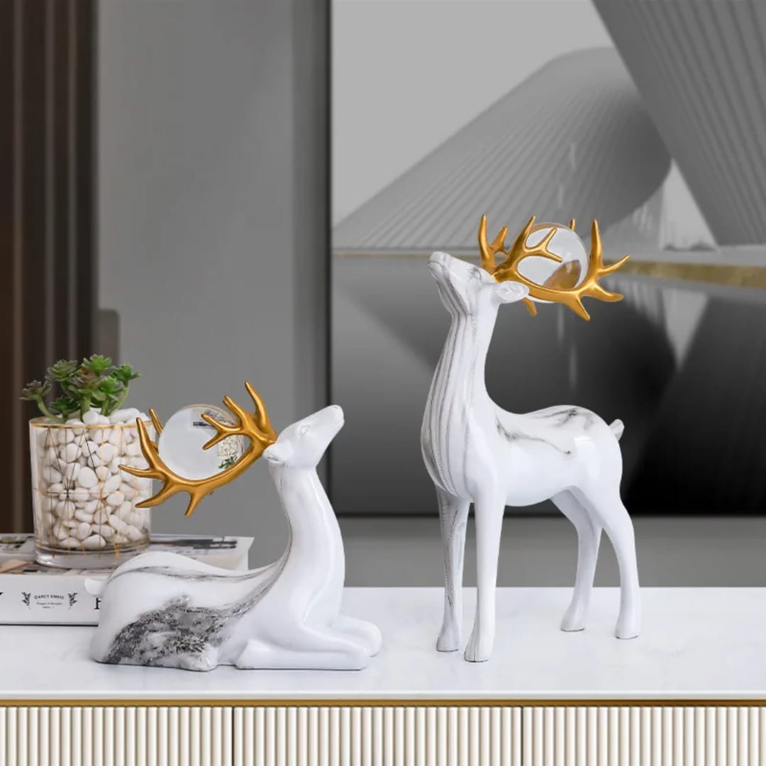 Set of two resin fortune deer ornaments with crystal balls, elegant decorative pieces for home or office display. 