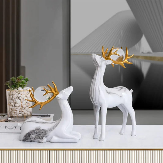 Set of two resin fortune deer ornaments with crystal balls, elegant decorative pieces for home or office display. 