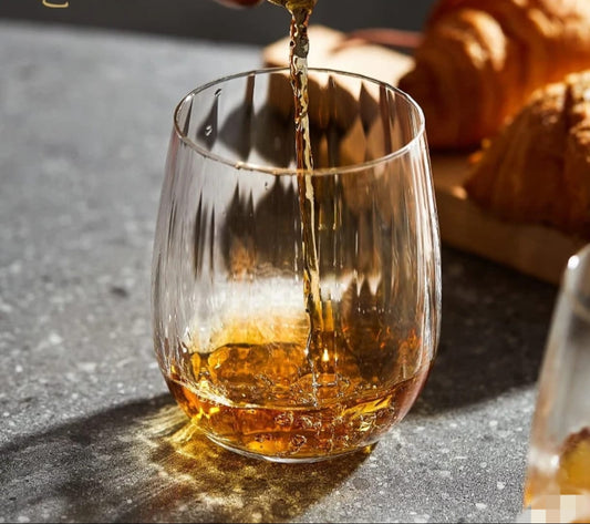 Set of six short ribbed drinking glasses made of clear glass.