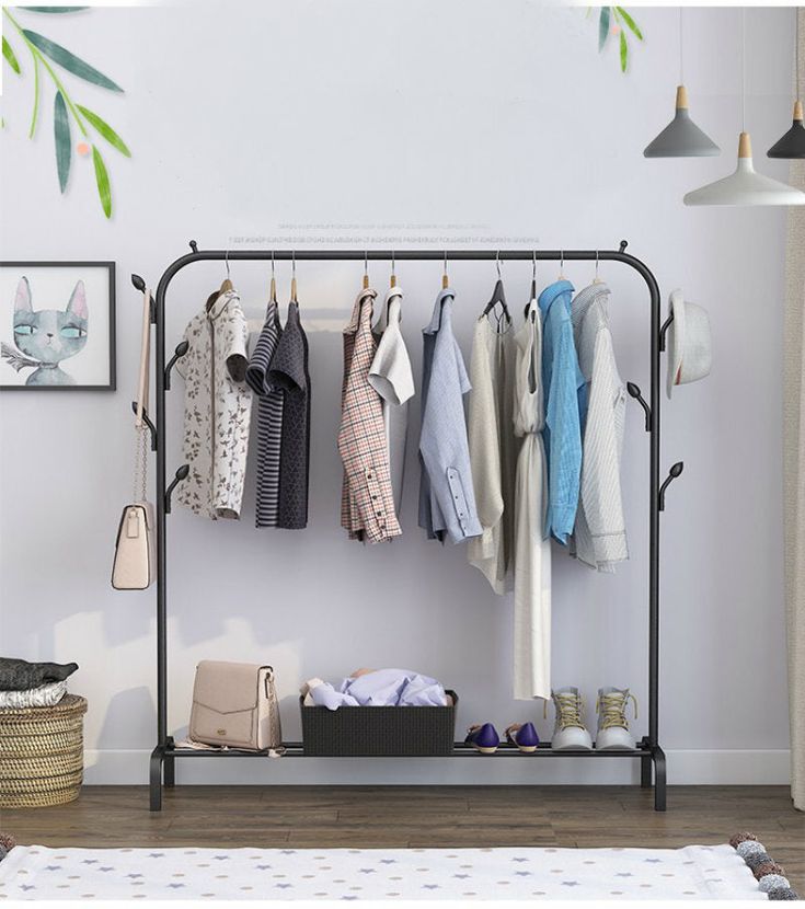 Single pole standing clothes drying rack with shoe shelf, side hooks, and wheels.