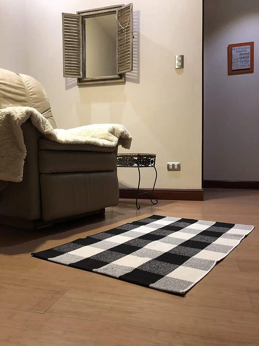 Black and white checkered woven rug measuring 60x90cm for modern home decor.