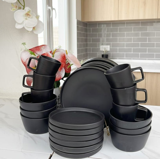 24-piece black stoneware dinner set with cups, bowls, side plates, and dinner plates