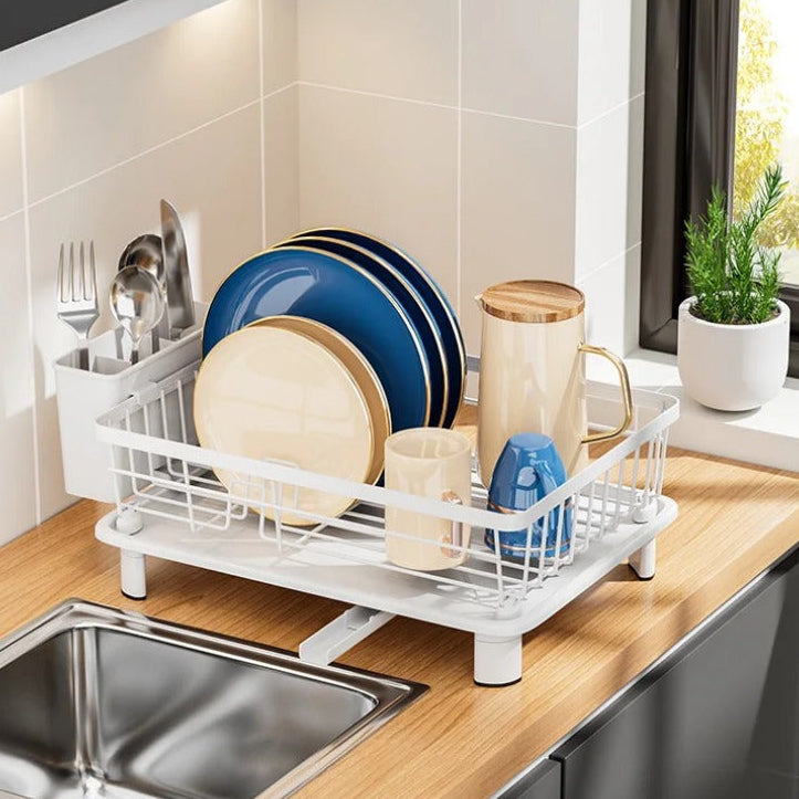 Minimalist countertop dish drying rack with a white coated metal frame, removable utensil holder, and integrated drainage spout for organized kitchen drying.